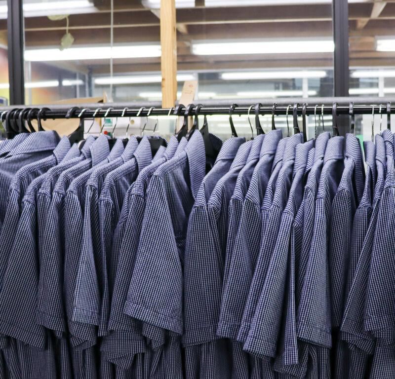 A row of uniform shirts on hangers